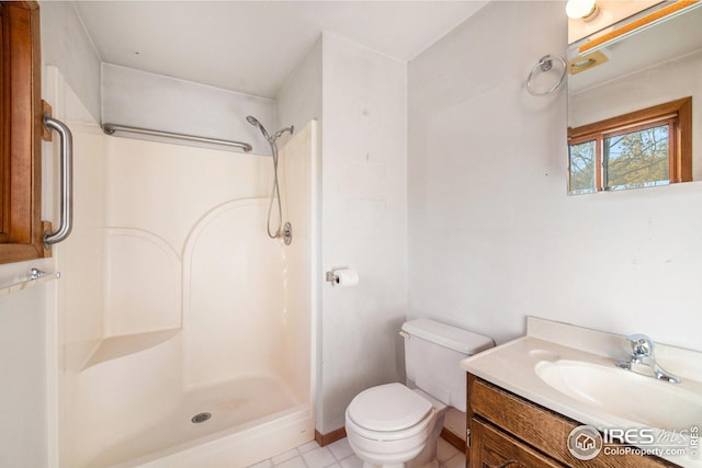 bathroom with toilet, tile patterned flooring, vanity, and a shower