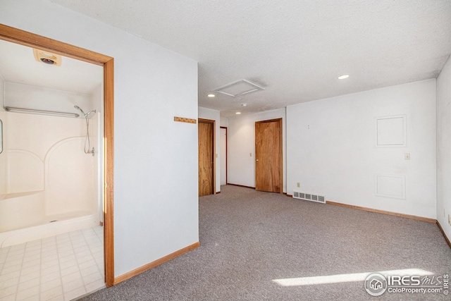 carpeted empty room featuring a textured ceiling