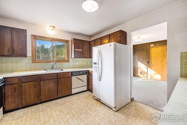 kitchen with decorative backsplash, white appliances, dark brown cabinetry, and sink