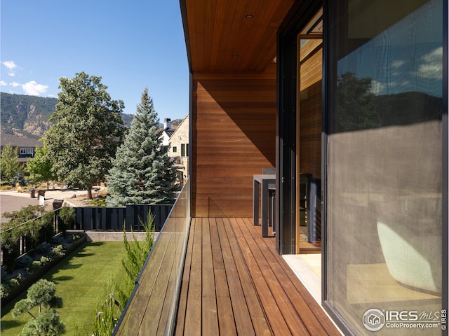 deck featuring a mountain view and a lawn