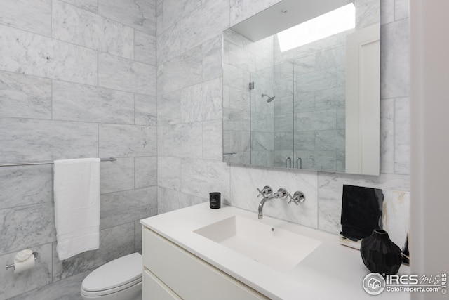 bathroom featuring vanity, toilet, and tiled shower