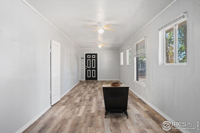 corridor featuring ornamental molding and light hardwood / wood-style floors