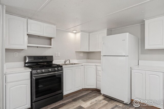 kitchen with range, white fridge, white cabinetry, and dark wood-type flooring