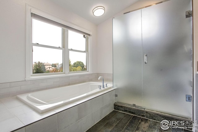 bathroom with shower with separate bathtub and lofted ceiling