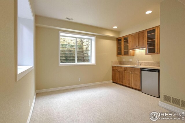 kitchen featuring dishwasher, light carpet, and sink