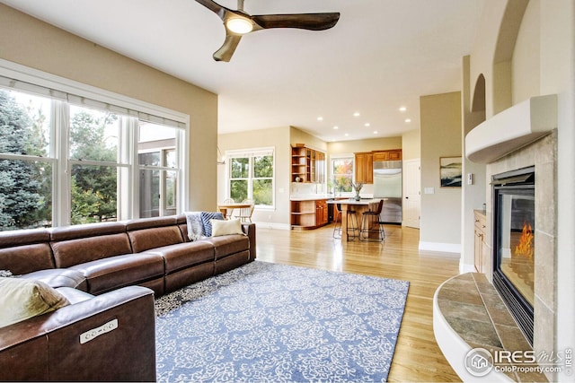 living room featuring ceiling fan and light wood-type flooring