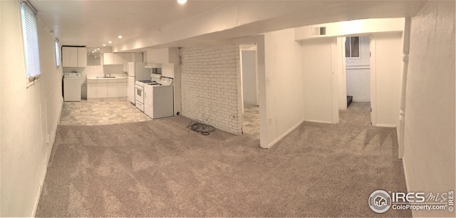 interior space featuring washer / dryer, sink, brick wall, and light colored carpet