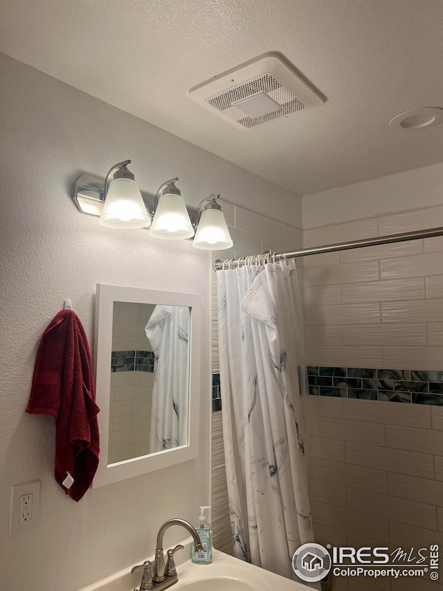 bathroom featuring walk in shower and sink