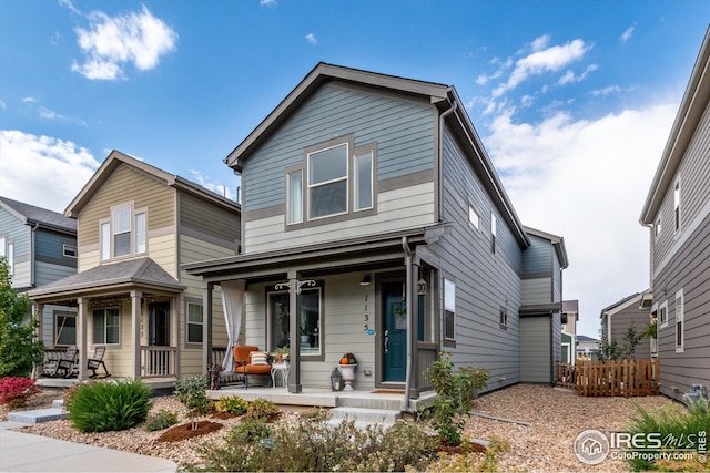 1135 Hummingbird Cir, Longmont, CO 80501 - traditional-style house featuring a porch and fence