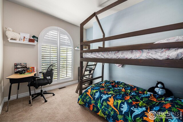 carpeted bedroom with lofted ceiling