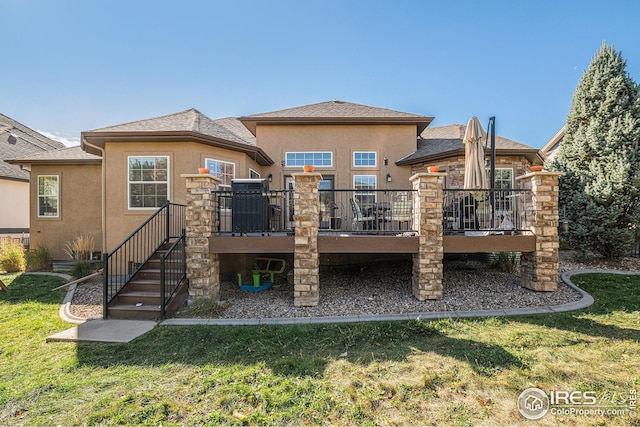 back of property featuring a wooden deck and a yard