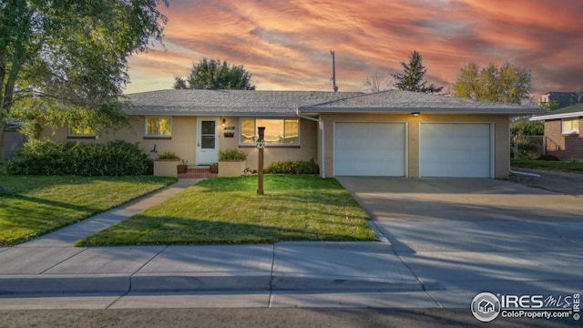 ranch-style house featuring a yard and a garage