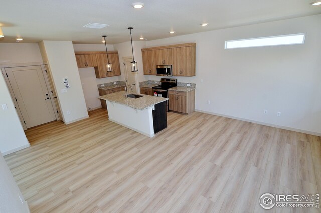 kitchen featuring light hardwood / wood-style flooring, an island with sink, stainless steel appliances, sink, and decorative light fixtures