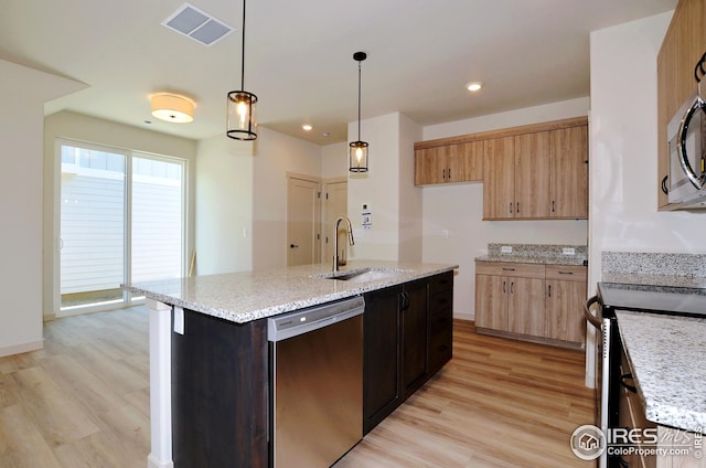 kitchen with hanging light fixtures, a kitchen island with sink, sink, light hardwood / wood-style floors, and stainless steel appliances