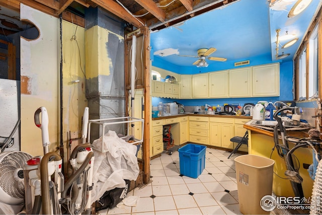 kitchen featuring light tile patterned floors, cream cabinetry, a sink, and ceiling fan