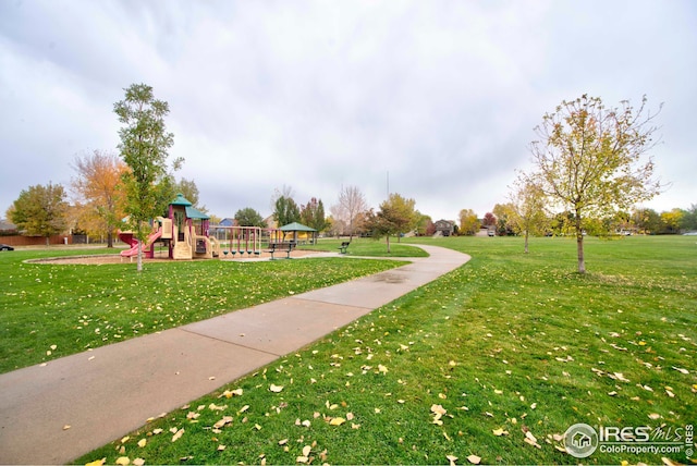 view of property's community with a playground and a yard