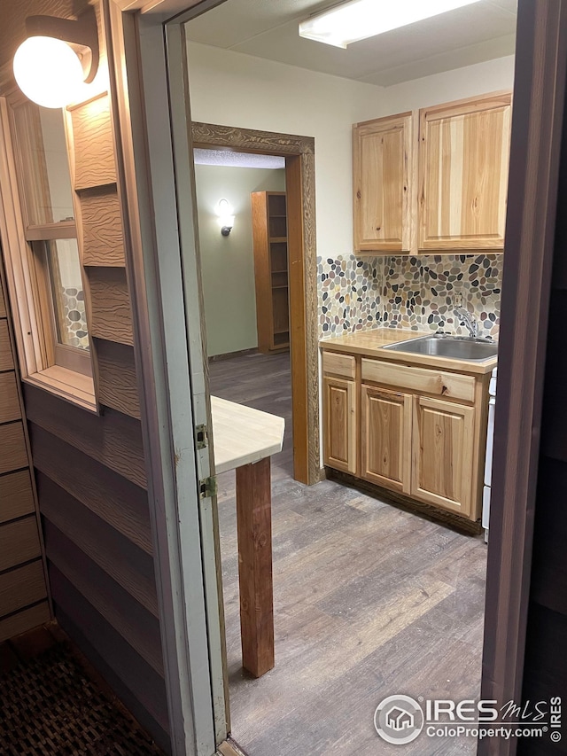 kitchen featuring white range, light brown cabinets, light hardwood / wood-style flooring, backsplash, and sink