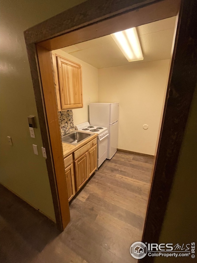 kitchen featuring decorative backsplash, light brown cabinets, wood-type flooring, sink, and white fridge