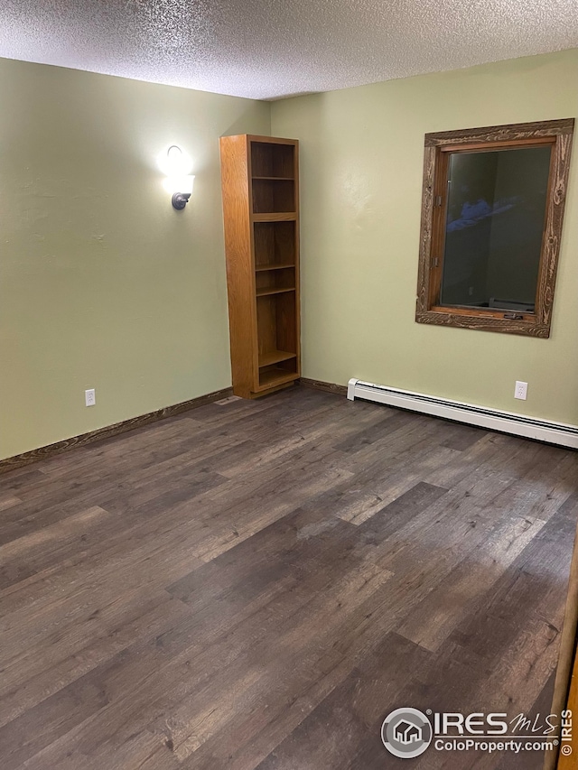 empty room featuring a textured ceiling, a baseboard radiator, and dark hardwood / wood-style floors