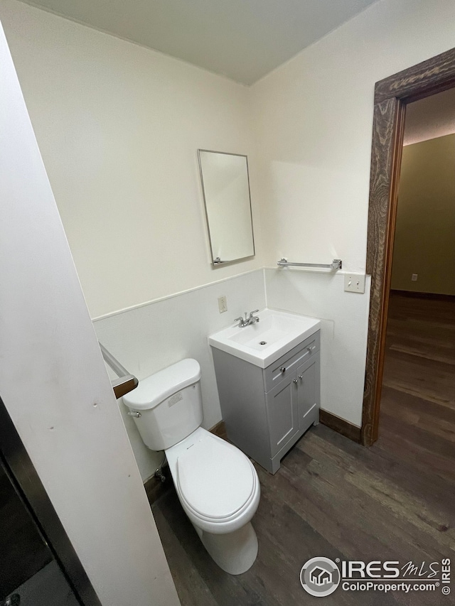 bathroom with vanity, wood-type flooring, and toilet