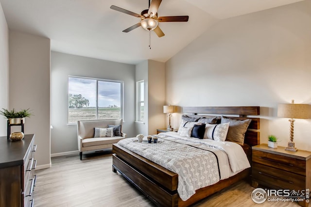 bedroom featuring ceiling fan, light wood-type flooring, and vaulted ceiling