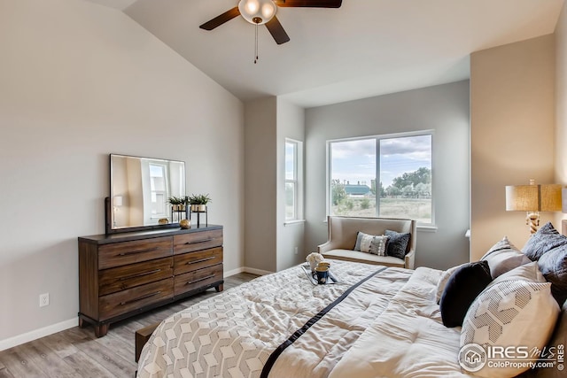 bedroom with light hardwood / wood-style floors, vaulted ceiling, and ceiling fan