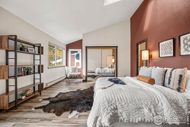 bedroom with lofted ceiling, hardwood / wood-style floors, and baseboard heating