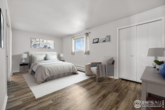 bedroom featuring a textured ceiling, a baseboard radiator, a closet, and dark hardwood / wood-style floors