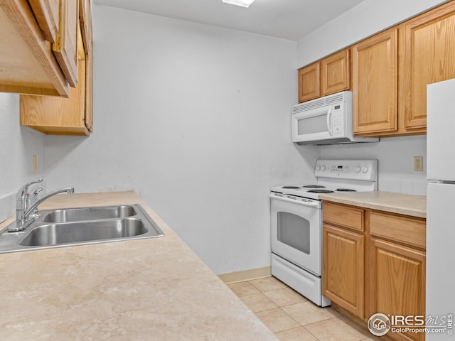 kitchen featuring light tile patterned flooring, white appliances, and sink