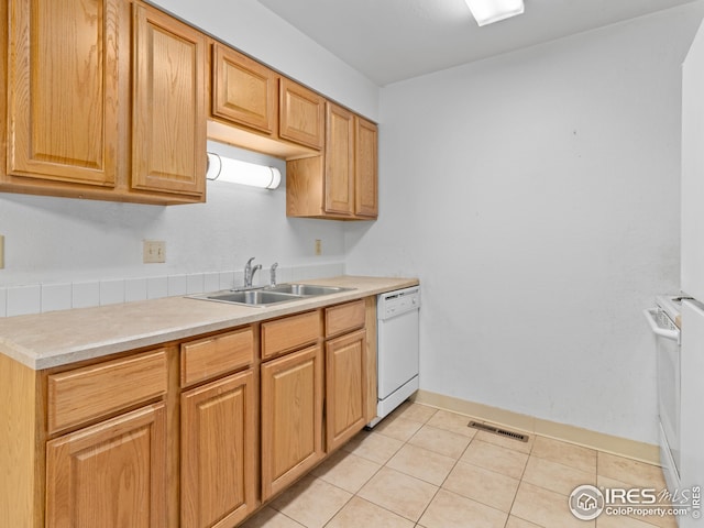 kitchen with dishwasher, light tile patterned floors, and sink