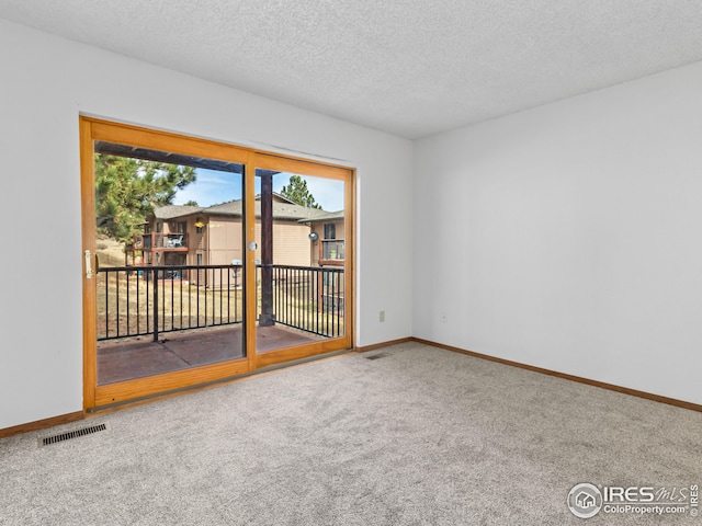 spare room featuring carpet floors and a textured ceiling