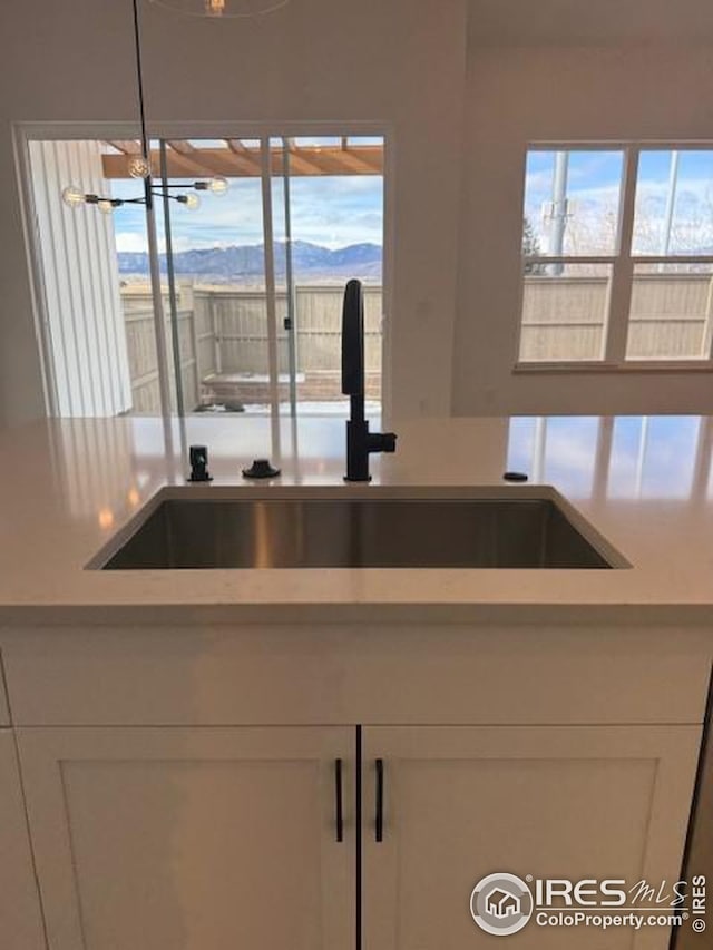 kitchen featuring light countertops, a sink, and white cabinetry