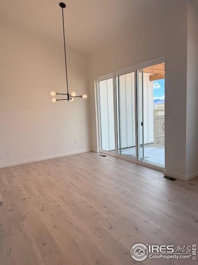 interior space with a chandelier, visible vents, light wood-style flooring, and baseboards