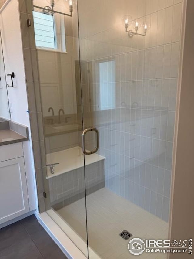 full bathroom with a stall shower, tile patterned flooring, and vanity