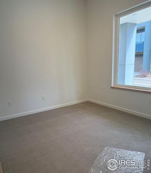 empty room with carpet floors and baseboards