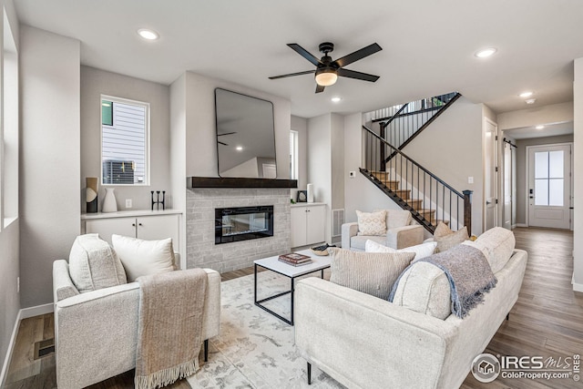 living room featuring a wealth of natural light, light wood-type flooring, and ceiling fan