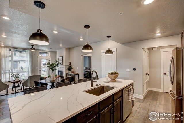 968 Birdwhistle Ln Unit 3, Fort Collins, CO 80524 - kitchen featuring appliances with stainless steel finishes, a textured ceiling, light wood-type flooring, and a sink