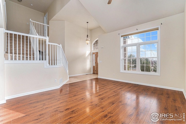 interior space with stairs, ceiling fan, wood-type flooring, and baseboards