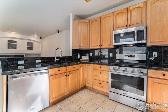 kitchen with tasteful backsplash, tile counters, appliances with stainless steel finishes, and a sink
