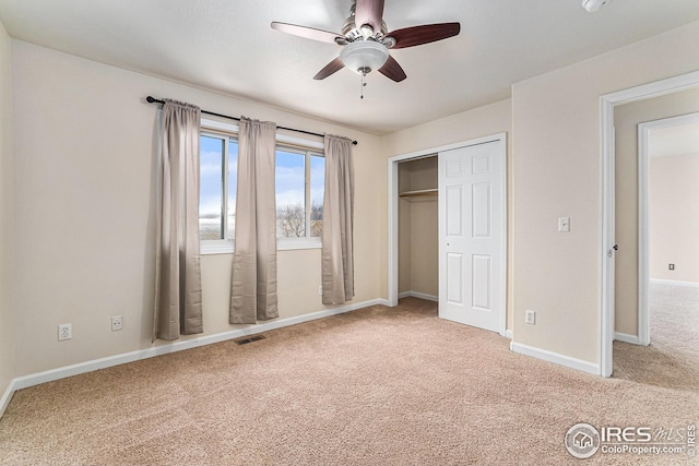 unfurnished bedroom featuring baseboards, visible vents, ceiling fan, carpet flooring, and a closet