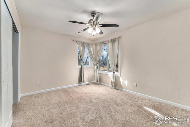 empty room with ceiling fan, carpet floors, and baseboards
