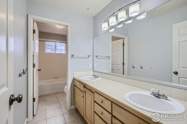 full bathroom with double vanity, tile patterned flooring, a sink, and toilet