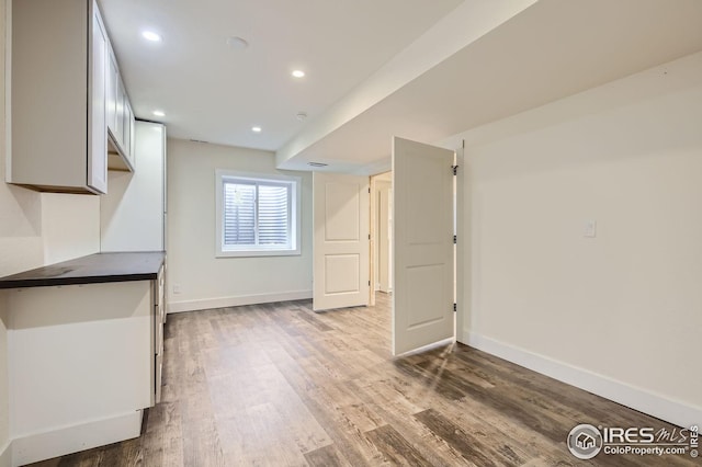 interior space with baseboards, wood finished floors, and recessed lighting