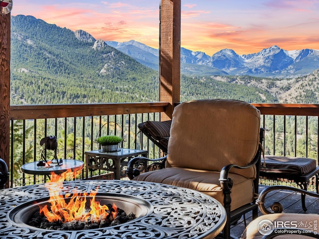 deck at dusk featuring a mountain view and an outdoor fire pit