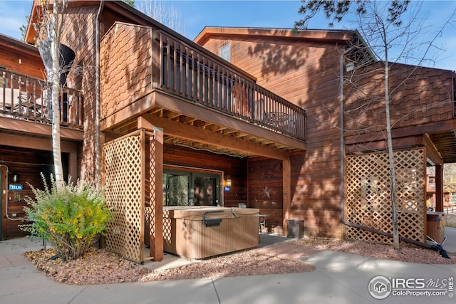 rear view of property featuring a patio area and a balcony