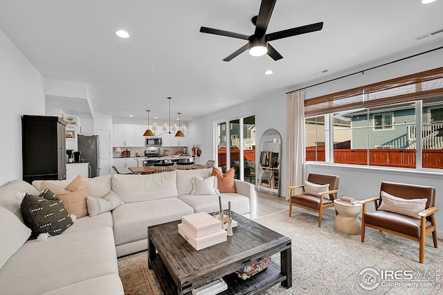 living room featuring ceiling fan and light hardwood / wood-style flooring