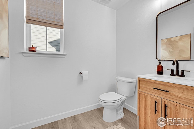 bathroom featuring wood-type flooring, vanity, and toilet