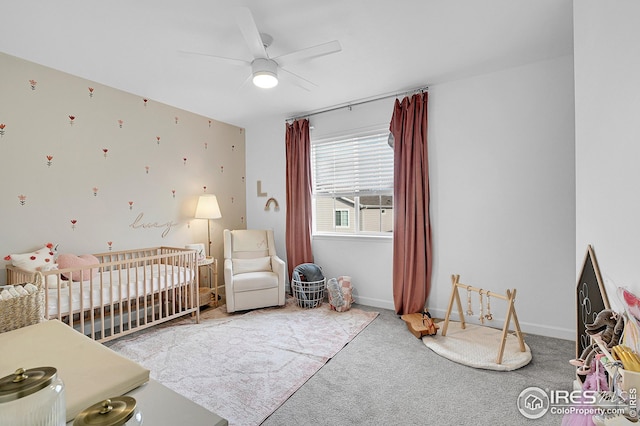 bedroom with carpet flooring, ceiling fan, and a crib