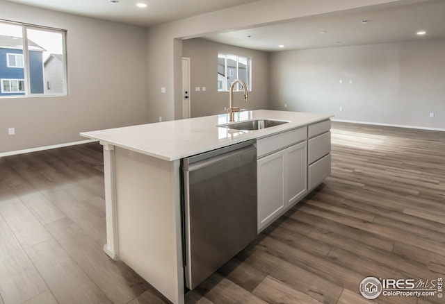 kitchen featuring dark wood-type flooring, sink, dishwasher, and a kitchen island with sink