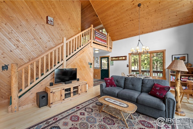 living area with high vaulted ceiling, wooden ceiling, stairway, and an inviting chandelier